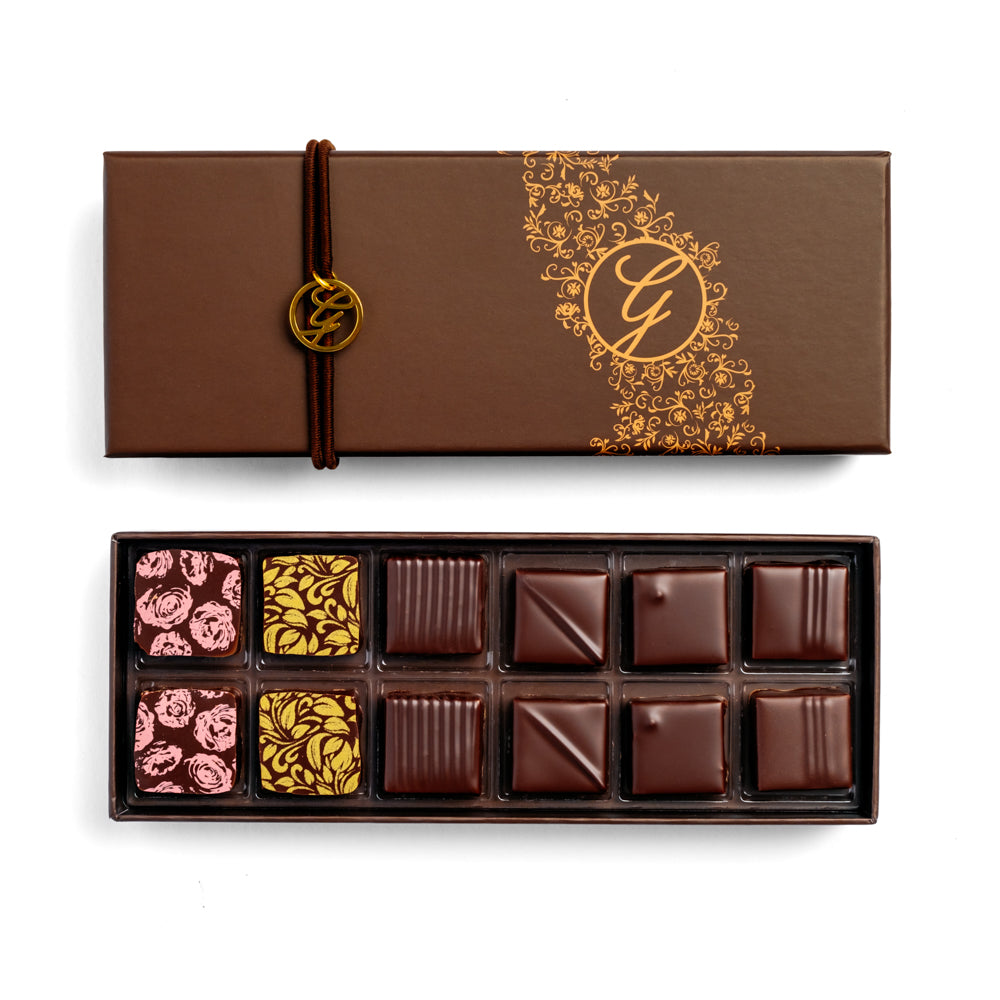 open 12-piece dark chocolate box arranged below closed box on white background
