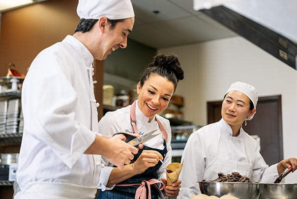 image of Ginger Elizabeth working in kitchen with Chef Daniel and Chef Holly. 