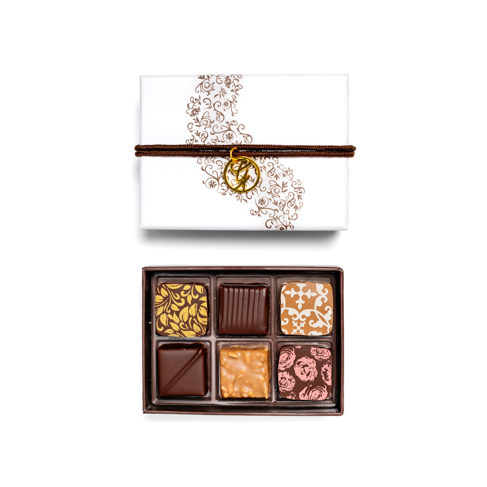 open 6-piece chocolate box arranged below closed box on white background