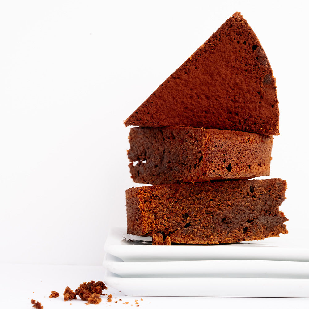 Ginger Elizabeth Chocolates stack of chocolate cake slices on stack of white plates on white background