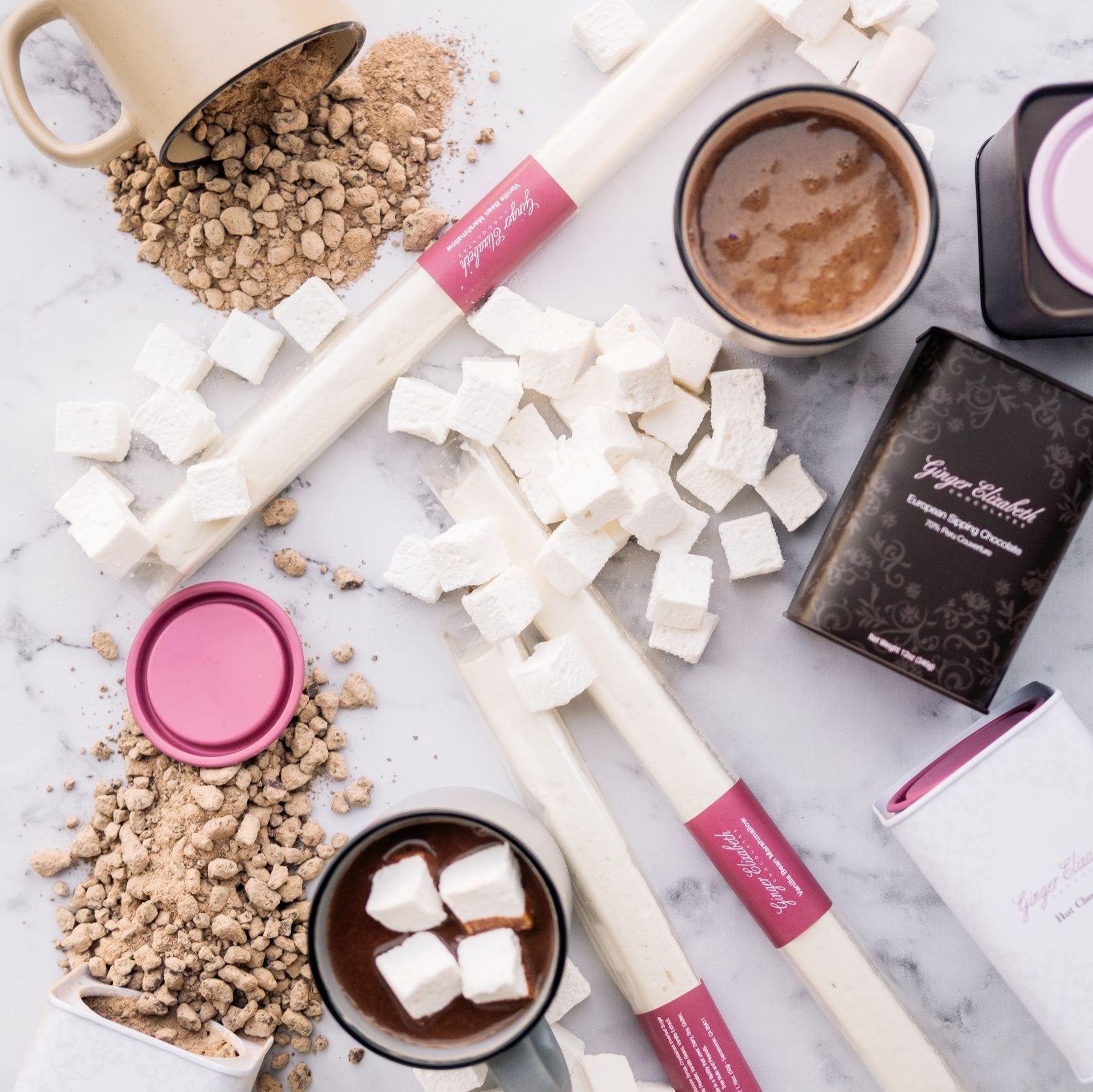 Vanilla Bean Marshmallows and Hot Chocolate tins with mugs of powdered and mixed cocoa